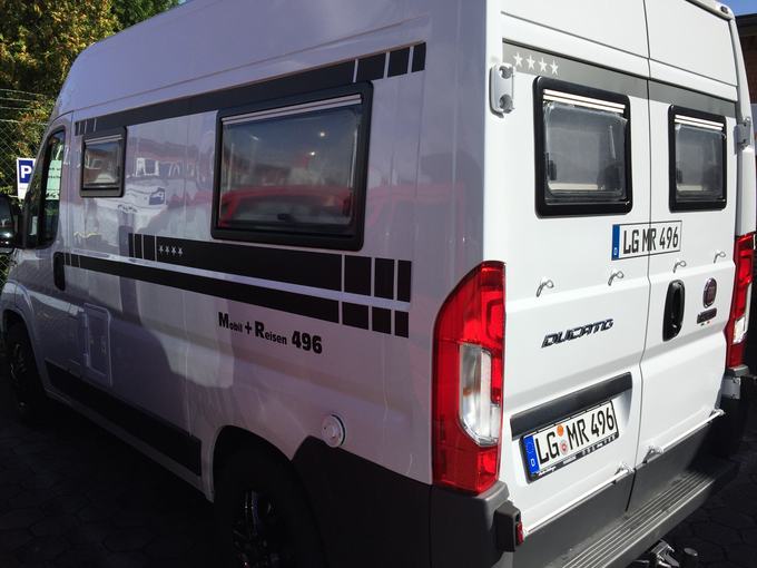 Weißer Transporter mit Firmenbeschriftung