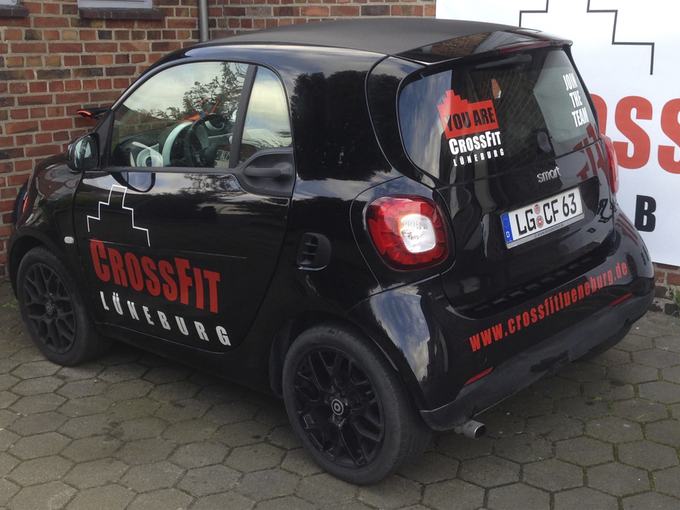 Schwarzer Kleinwagen mit Beschriftung eines Fitnessstudios